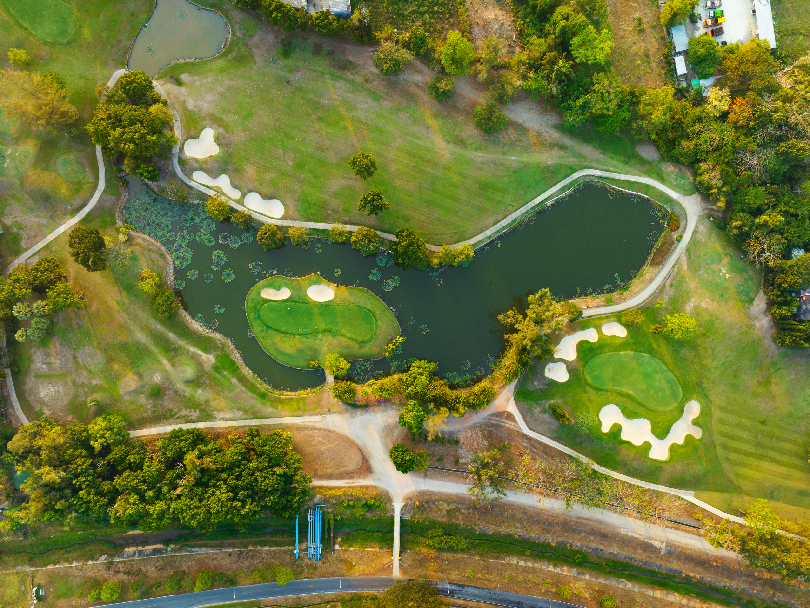 Aerial view of a sustainable golf course design acting as an urban green lung in a smart city