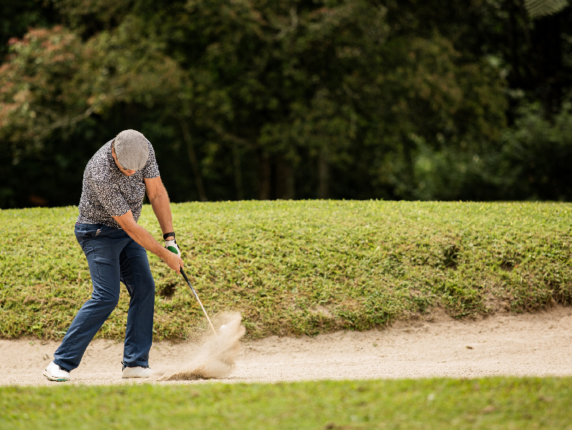 Architect inspecting sand-face stability and liners on a desert golf course hazard